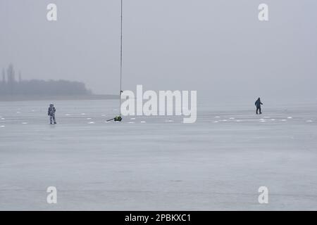 Voronesch, Russland. 11. März 2023. Wanderfischer und Ausrüstung auf dem dünnen Quelleis des Voronesch-Reservoirs. Jedes Jahr nehmen verzweifelte Liebhaber des Winterfischens das Eis des Voronesch-Reservoirs. Die Fischer werden nicht durch ein Auftauen oder sogar das Eintreffen des Frühlings aufgehalten. Die Aufregung treibt diese Menschen auf dünnem und manchmal verschwommenem Eis an, was zu Spannungen für den Dienst der Stadt führt. Rettungskräfte und Polizisten entfernen Fischer aus Eisschollen und fischen sie aus Gully, während medizinische Arbeiter um das Leben von Menschen kämpfen, die ertrinken oder kalt sind. Kredit: SOPA Images Limited/Alamy Live News Stockfoto