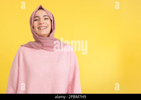 Eine schöne junge muslimische Frau, die lächelnd Hijab trägt Stockfoto