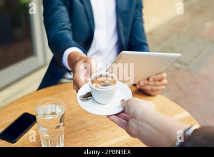 Ihr Espresso, Sir. Ein Geschäftsmann, der in einem Straßencafé Kaffee serviert bekommt. Stockfoto