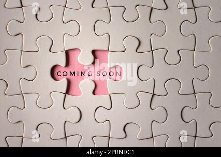 Bild von oben mit Puzzle-Puzzle und DEMNÄCHST erscheinendem Text. Geschäftskonzept Stockfoto