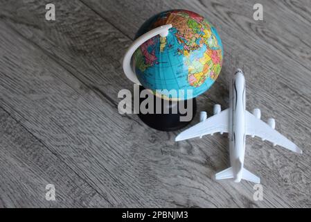 Bild von oben mit Weltkugel und Spielzeugflugzeug mit Kopierbereich. Reise- und Urlaubskonzept Stockfoto