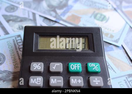 Nahaufnahme von Geld und Taschenrechner mit Nummer 2023 auf dem Display. Finanzplanungskonzept Stockfoto