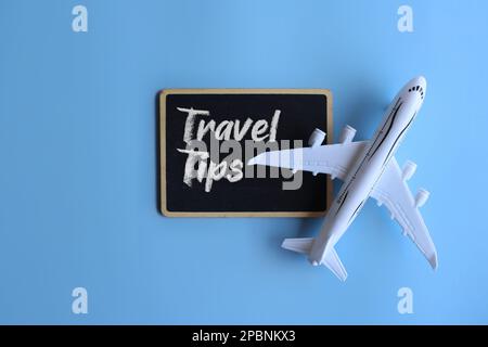 Spielzeugflugzeug und Tafel mit REISETIPPS für Text. Reise- und Transportkonzept Stockfoto