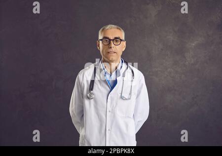 Porträt eines reifen Mannarztes in weißer medizinischer Uniform Stockfoto