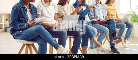 Verschiedene Menschen in Freizeitkleidung, die Notebooks und Laptops während des persönlichen Entwicklungstrainings verwenden. Stockfoto