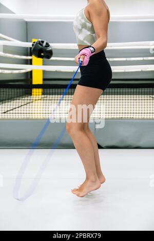 Ein Sportler, der im Fitnessstudio vor dem Ring über das Seil springt Stockfoto