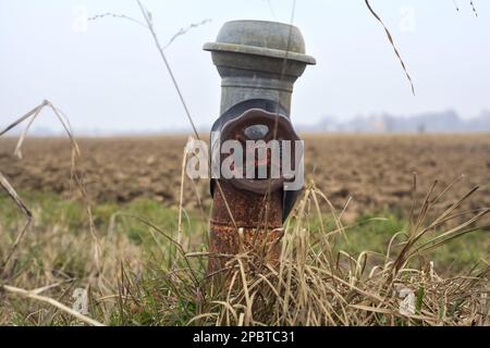 Rostiger Wasserhahn auf einem Feld aus der Nähe Stockfoto