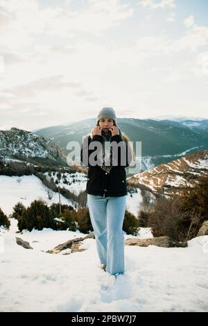 Porträt eines Mädchens mit Hut und schneebedeckten Bergen im Hintergrund Stockfoto