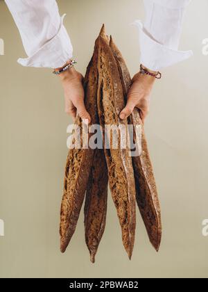 Ein Mädchen hält ein französisches Baguette auf einem Holzbrett Stockfoto