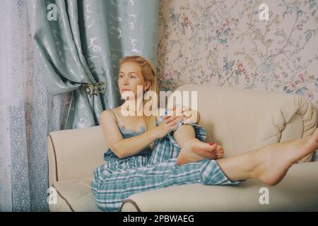 Frau mittleren Alters, die im Schlafzimmer sitzt, genießen Sie einen guten Morgen Stockfoto