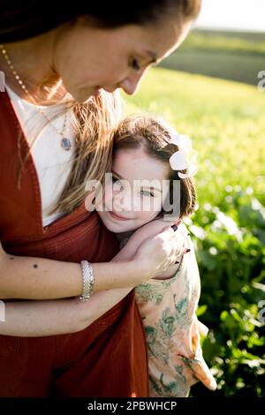 Die 7-jährige umarmt Mom im Außendienst in San Diego Stockfoto