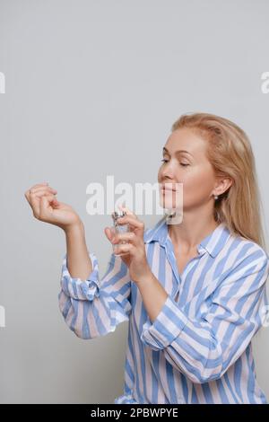 Wunderschöne, reife, ältere Frau mit parfum Stockfoto