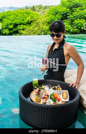 Schöne Frau genießt ein schwimmendes Frühstück in Thailand Stockfoto