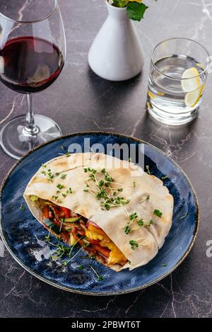 türkische Pita mit Fleisch, Gemüse und Sauce auf einem Teller Stockfoto