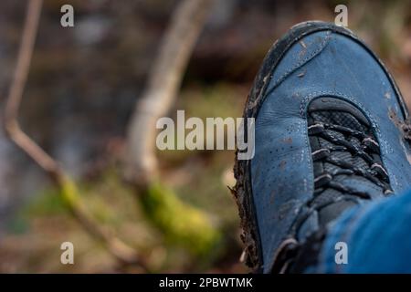 Schlammbedeckte Wanderschuhe und Sohle im Freien. Tagsüber, keine Menschen, Nahaufnahme. Stockfoto