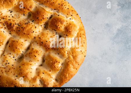 Traditionelle Ramadan-Pita auf hellblauem Hintergrund. Heiliges Brot für Muslime Stockfoto