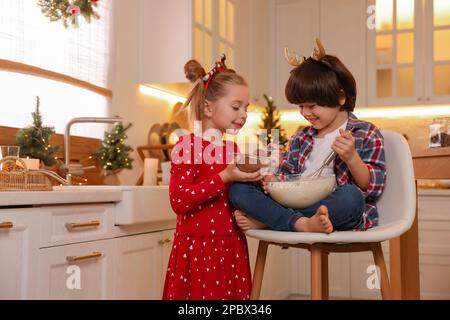 Süße kleine Kinder machen Teig für Weihnachtskekse in der Küche Stockfoto