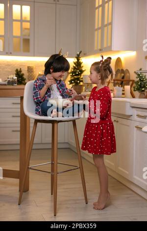 Süße kleine Kinder machen Teig für Weihnachtskekse in der Küche Stockfoto