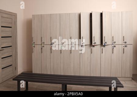 Holzbank und Schließfächer im Umkleideraum Stockfoto