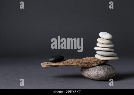 Steine mit Baumzweig auf schwarzem Hintergrund. Konzept von Harmonie und Balance Stockfoto