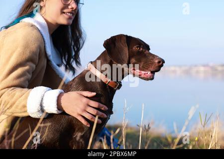 Eine Frau mit ihrem deutschen Hündchen in Flussnähe, Nahaufnahme Stockfoto