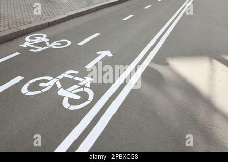 Zweiwege-Fahrradweg mit weißen Schildern auf Asphalt Stockfoto