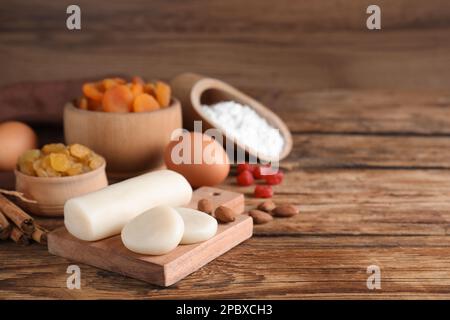 Marzipan und andere Zutaten für hausgemachtes Stollen auf einem Holztisch. Traditionelles deutsches Weihnachtsbrot backen Stockfoto