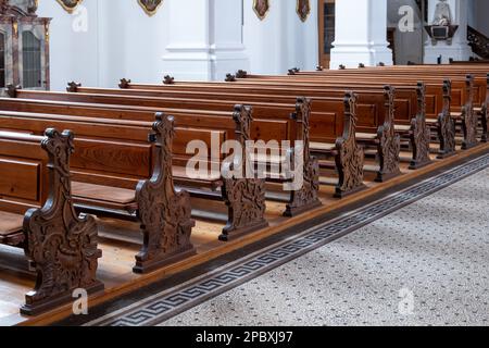 Leere hölzerne Kirchenbänke, keine Menschen. Stockfoto