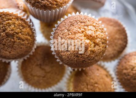 Blick von oben auf eine Gruppe frisch gebackener Cupcakes mit geringer Schärfentiefe. Stockfoto