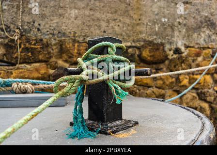 Metallankerpfosten auf einem Fischerboot mit einem Wirrwarr aus blauen Anlegeseilen, Großbritannien Stockfoto