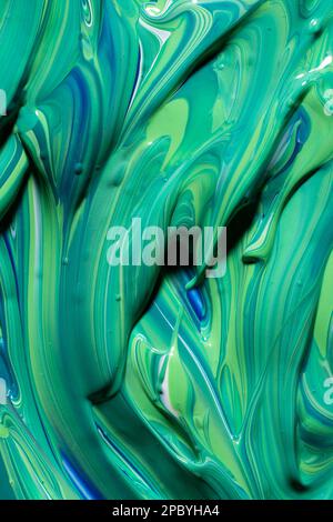Nahaufnahme des dicken grünen und blauen Pigments, das sich vermischt In smaragdgrüne Farbe Stockfoto
