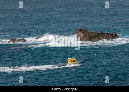 Das Passagier-Jetboot „Hurricane“, das Golden Ball Rock in einem rauen Meer vor der Nordküste von Tresco, Isles of Scilly, Cornwall, Großbritannien, passiert Stockfoto