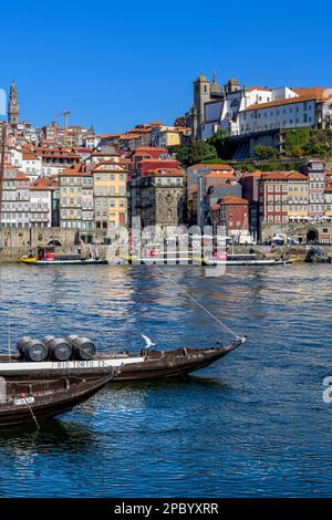 Der wunderschöne alte Hafen von Porto mit der Cais da Ribeira auf der gegenüberliegenden Seite des Flusses Douro. Die eindrucksvolle Bogenbrücke ist die Luis-I-Brücke. Stockfoto
