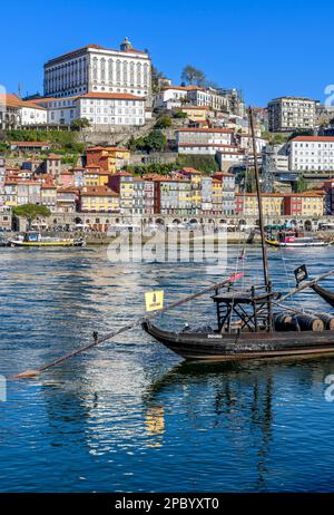 Der wunderschöne alte Hafen von Porto mit der Cais da Ribeira auf der gegenüberliegenden Seite des Flusses Douro. Die eindrucksvolle Bogenbrücke ist die Luis-I-Brücke. Stockfoto