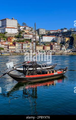 Der wunderschöne alte Hafen von Porto mit der Cais da Ribeira auf der gegenüberliegenden Seite des Flusses Douro. Die eindrucksvolle Bogenbrücke ist die Luis-I-Brücke. Stockfoto