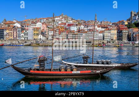 Der wunderschöne alte Hafen von Porto mit der Cais da Ribeira auf der gegenüberliegenden Seite des Flusses Douro. Die eindrucksvolle Bogenbrücke ist die Luis-I-Brücke. Stockfoto
