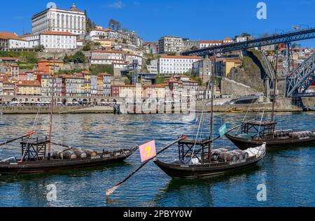 Der wunderschöne alte Hafen von Porto mit der Cais da Ribeira auf der gegenüberliegenden Seite des Flusses Douro. Die eindrucksvolle Bogenbrücke ist die Luis-I-Brücke. Stockfoto