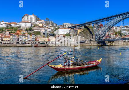 Der wunderschöne alte Hafen von Porto mit der Cais da Ribeira auf der gegenüberliegenden Seite des Flusses Douro. Die eindrucksvolle Bogenbrücke ist die Luis-I-Brücke. Stockfoto