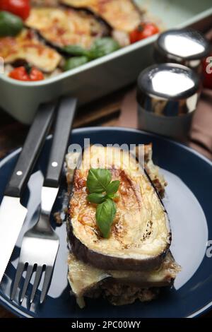 Teller mit leckerer Auberginen-Lasagne und Besteck auf dem Tisch Stockfoto
