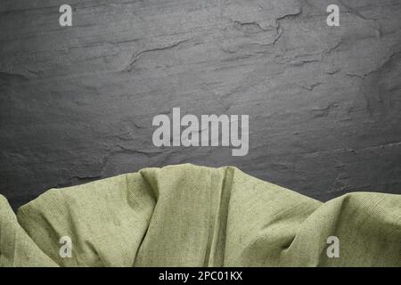 Natürliches Leinengewebe auf schwarzem Tisch, Draufsicht. Platz für Text Stockfoto