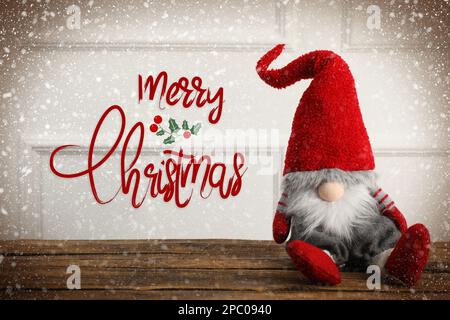 Frohe Weihnachten! Süßer Zwerg auf Holztisch Stockfoto
