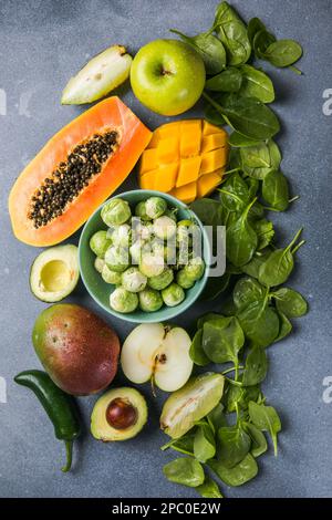 Gesunde Lebensmittel Auswahl an sauberen Speisen: Obst, Gemüse, Superfoods, Blattgemüse auf grauem Betonhintergrund Stockfoto