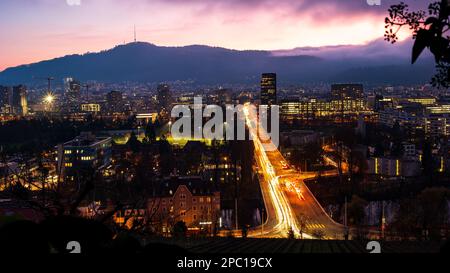 Langzeitwagenverkehr bei Nacht auf der Europabrücke in der Stadt Zürich, Schweiz. Hoher Aussichtspunkt. Stockfoto