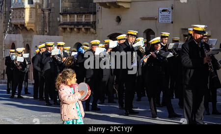 Das Fest von St. Gregory dem Großen, Kercem, Gozo. Ein Kind läuft mit seinem eigenen Tamburin neben einer Blaskapelle. Stockfoto