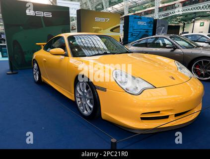 Dreiviertel Vorderansicht eines Gelben Porsche 996 Teil einer besonderen Feier der 60 Jahre seines berühmten Marques auf der London Classic Car Show 2023 Stockfoto