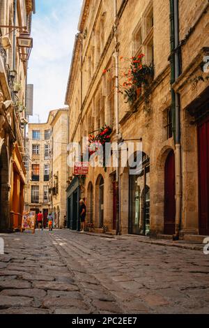Malerische Geschäfte und Fassaden auf der gepflasterten Straße Rue de la foire in der mittelalterlichen Altstadt Pezenas im Süden Frankreichs (Herault). Stockfoto