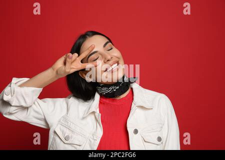 Modische junge Frau in stilvollem Outfit mit einem roten Bandana Stockfoto