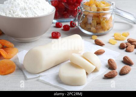 Marzipan und andere Zutaten für hausgemachtes Stollen auf weißem Holztisch. Traditionelles deutsches Weihnachtsbrot backen Stockfoto