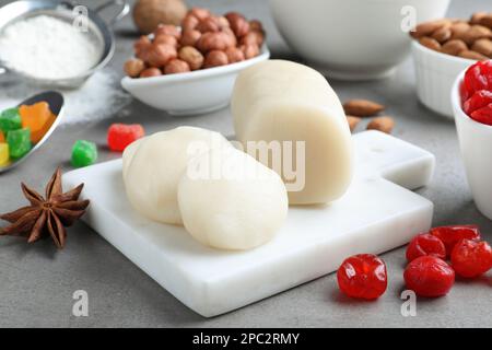 Marzipan und andere Zutaten für hausgemachtes Stollen auf grauem Tisch, Nahaufnahme. Traditionelles deutsches Weihnachtsbrot backen Stockfoto