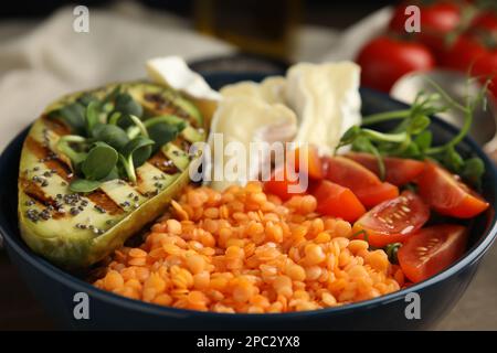 Köstliche Linsenschale mit Weichkäse, Avocado und Tomaten, Nahaufnahme Stockfoto